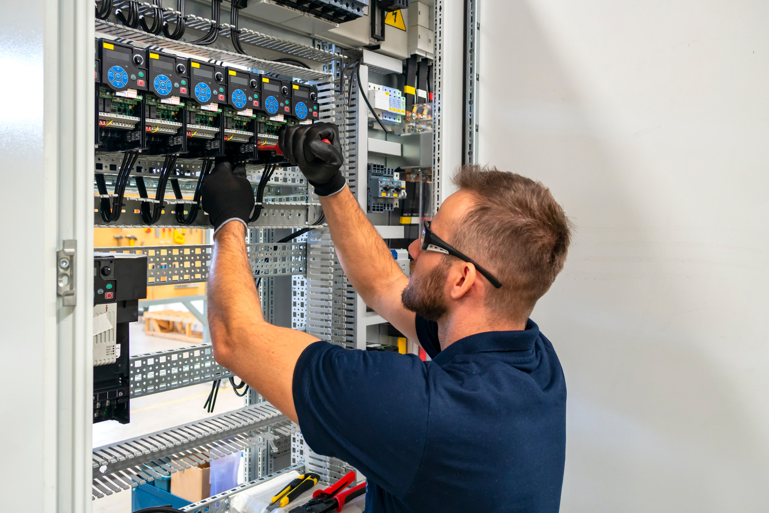 Electrician working at electric panel